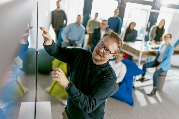 Bild eines Angestellten der Cloudogu GmbH, der etwas an einem Whiteboard zeigt